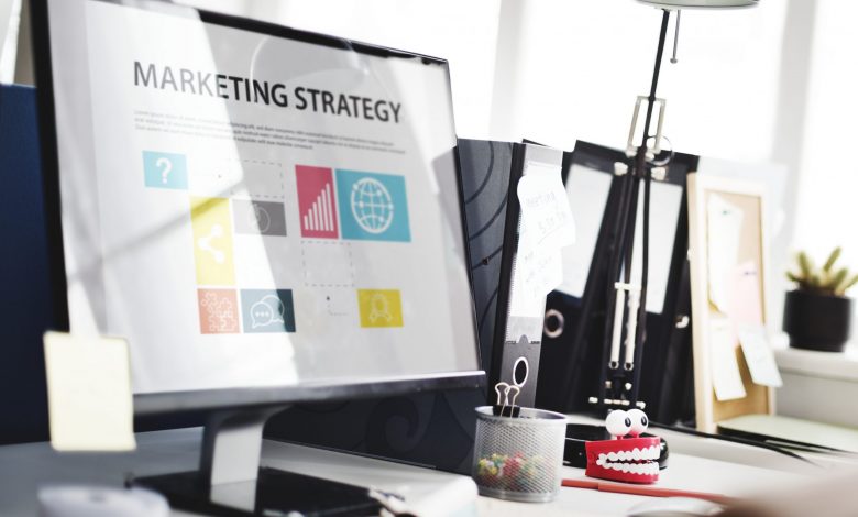 #PraCegoVer: Computador desktop em uma mesa de escritório escrito "Estratégia de Marketing" na tela.