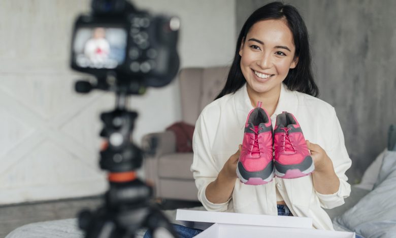 #PraCegoVer: Imagem de uma mulher realizando streaming live comercializando um sapato digitalmente.