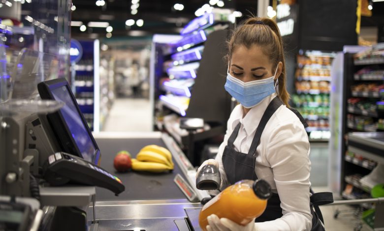 #PraCegoVer: Imagem de uma mulher trabalhando como caixa de supermecado e registrando uma compra.