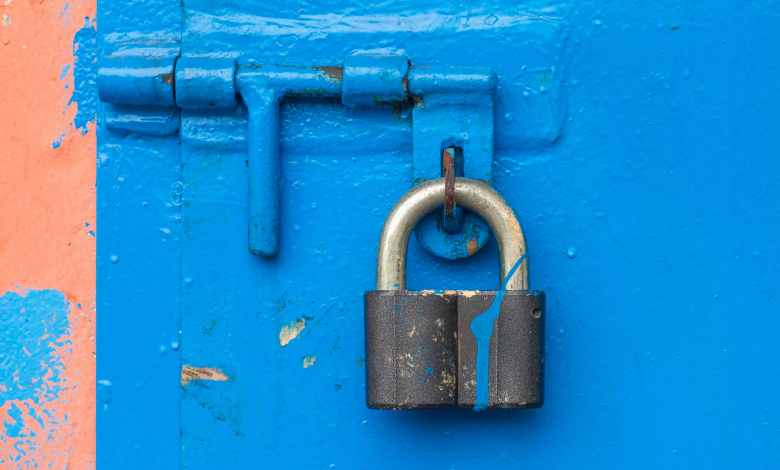 #PraCegoVer: Imagem de um cadeado em uma porta de madeira azul - Imagem Divulgação: Canva Pro